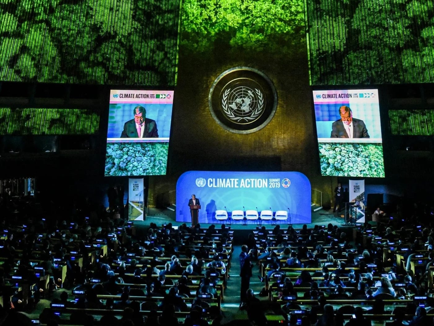 Delegates seated below the stage in the UN General Assembly hall at a climate summit.